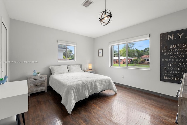 bedroom featuring baseboards, visible vents, dark wood-style floors, and multiple windows