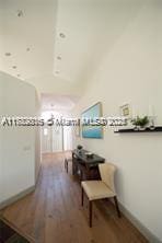 hallway with wood finished floors and baseboards