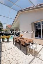 view of patio with a pool, outdoor dining area, and a lanai