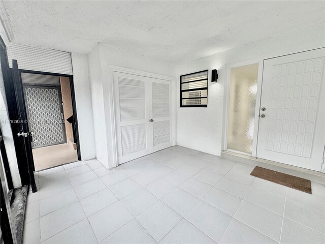 tiled entryway featuring a textured ceiling