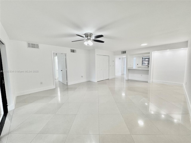 interior space featuring visible vents, a ceiling fan, and baseboards