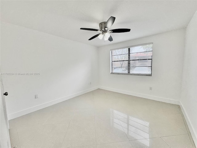 spare room featuring ceiling fan, baseboards, and light tile patterned floors