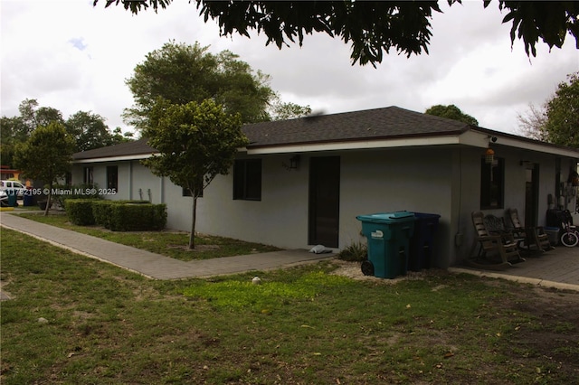 view of home's exterior with a yard, a patio, and stucco siding