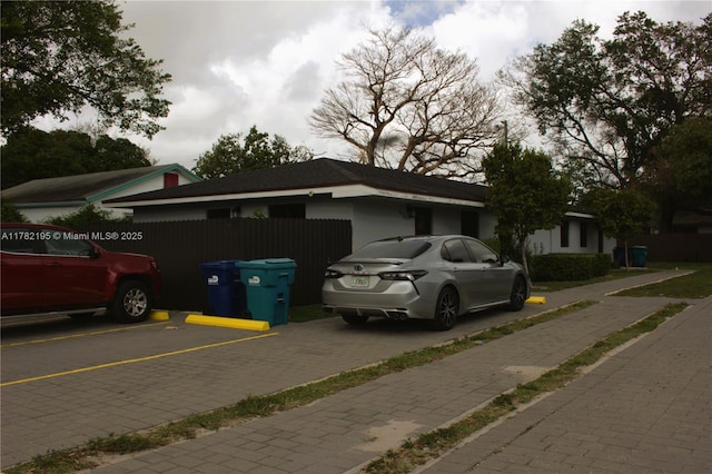 view of front of property featuring uncovered parking and fence