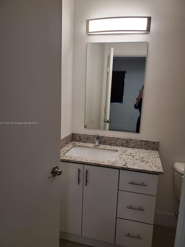 half bath featuring toilet and vanity