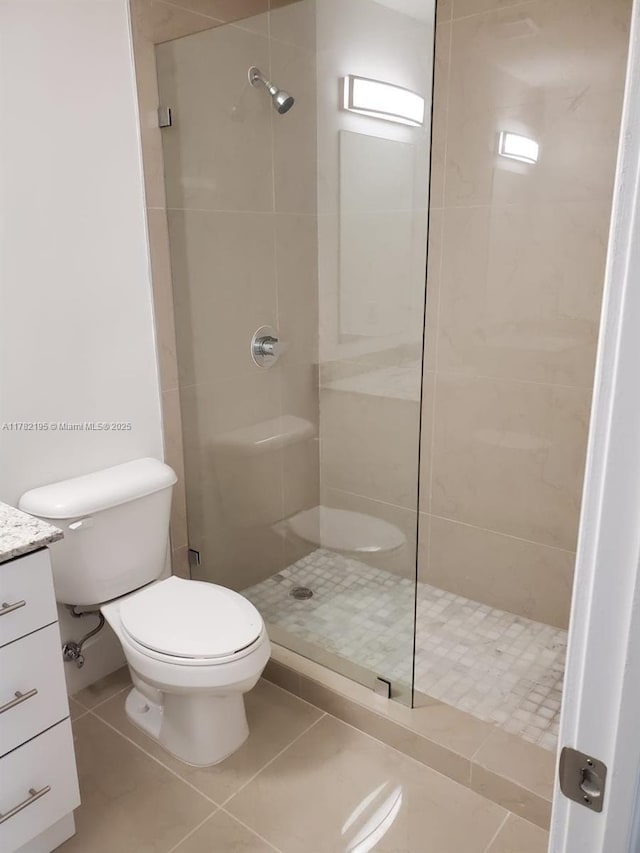 bathroom with toilet, tile patterned floors, a walk in shower, and vanity