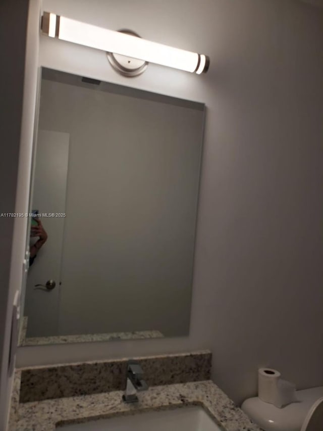 bathroom featuring toilet and vanity