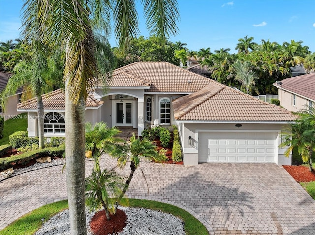 1807 Victoria Pointe Cir, Weston, FL 33327 - mediterranean / spanish house with french doors, stucco siding, a tiled roof, and a garage