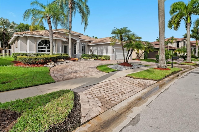 1807 Victoria Pointe Cir, Weston, FL 33327 - mediterranean / spanish home featuring stucco siding, decorative driveway, a tiled roof, an attached garage, and a front yard