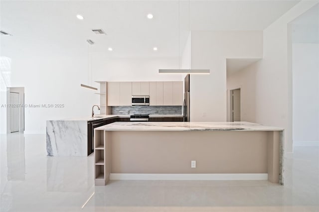 1807 Victoria Pointe Cir, Weston, FL 33327 - kitchen featuring stainless steel appliances, a peninsula, tasteful backsplash, modern cabinets, and light stone countertops