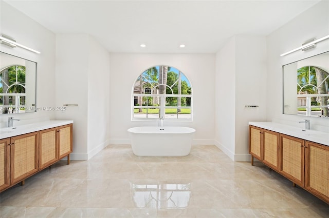 1807 Victoria Pointe Cir, Weston, FL 33327 - full bath featuring marble tiled floors, two vanities, a freestanding bath, baseboards, and recessed lighting