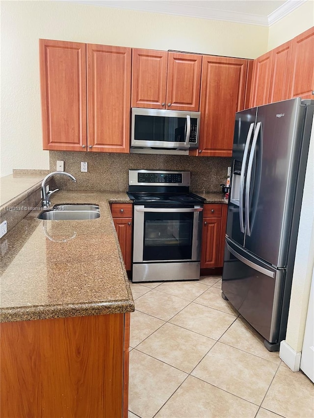 kitchen with crown molding, light tile patterned flooring, a sink, stainless steel appliances, and decorative backsplash
