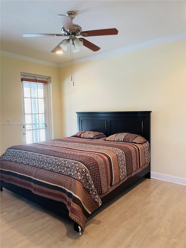 bedroom featuring ornamental molding, ceiling fan, wood finished floors, and baseboards