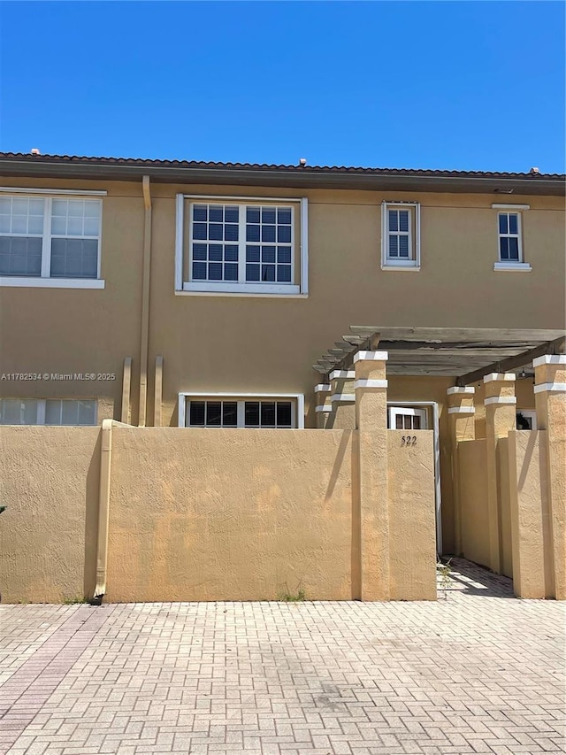 townhome / multi-family property featuring a fenced front yard and stucco siding