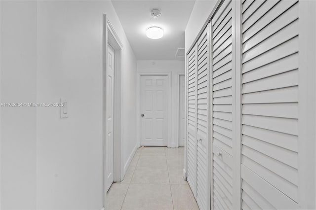 hallway with light tile patterned floors and baseboards