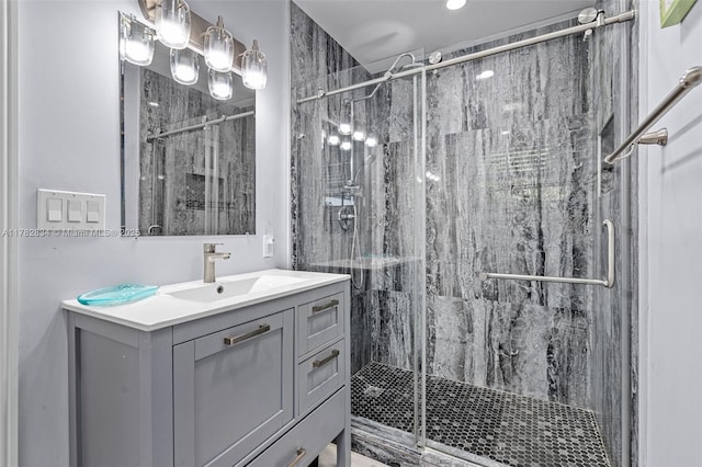 full bath featuring a marble finish shower and vanity