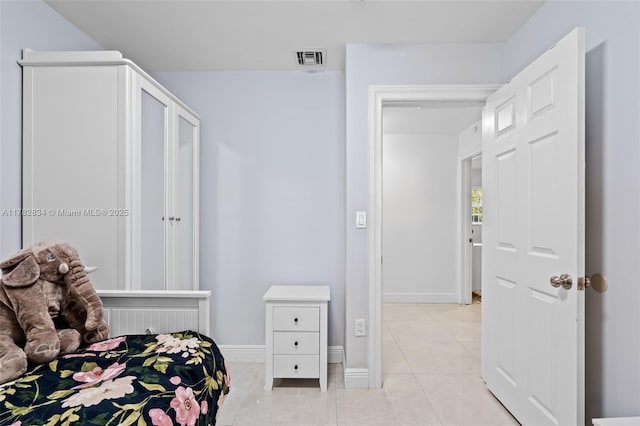 bedroom with baseboards, visible vents, and light tile patterned floors