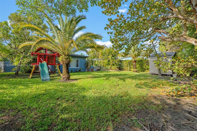 view of yard featuring a storage shed, a playground, and an outdoor structure