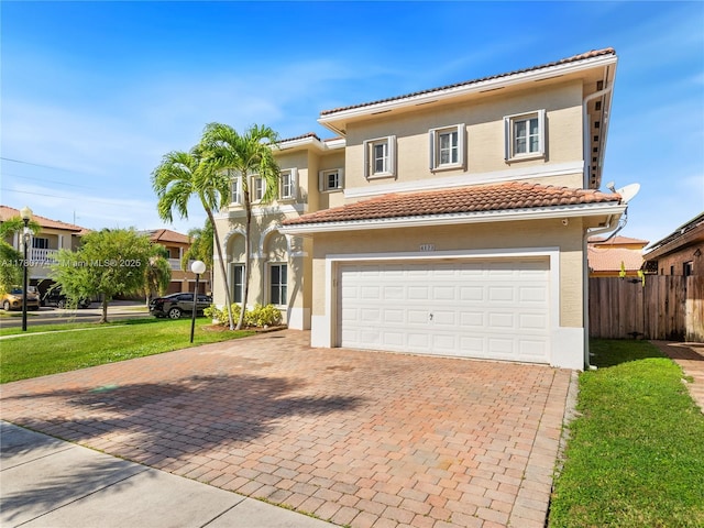 4173 NE 12th St, Homestead, FL 33033 - mediterranean / spanish-style home featuring stucco siding, decorative driveway, a front lawn, a tiled roof, and fence