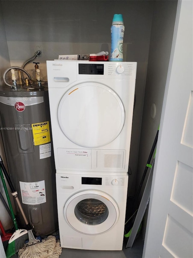 laundry area featuring water heater, stacked washer and clothes dryer, and laundry area