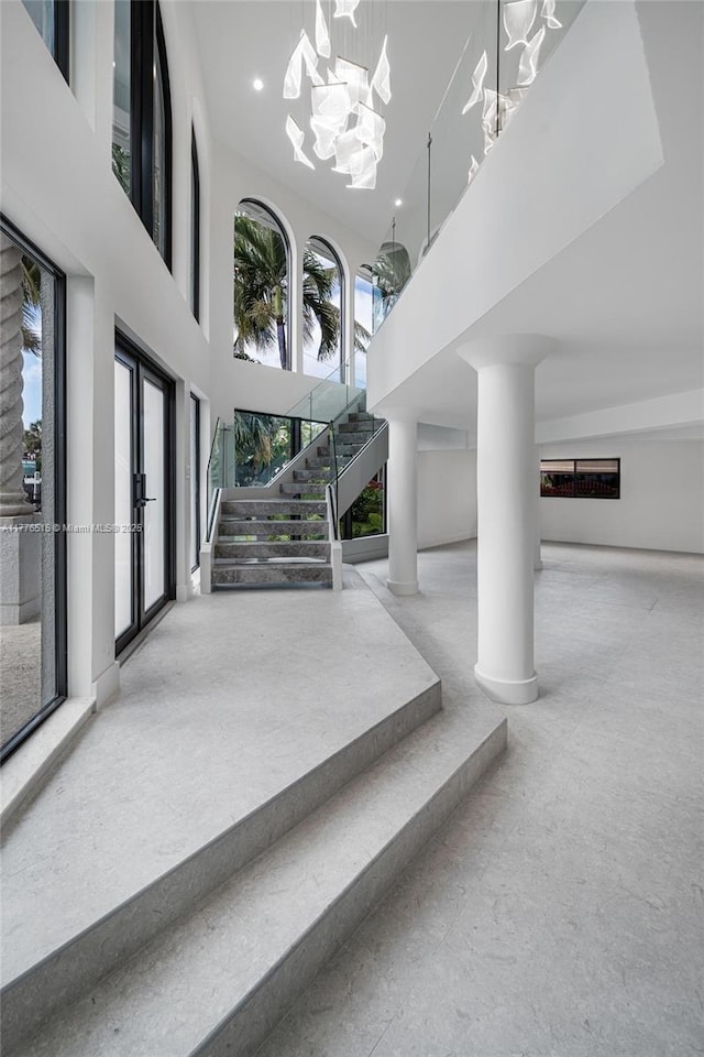 3321 NE 16th Pl, Fort Lauderdale, FL 33305 - stairs featuring a towering ceiling, baseboards, and a chandelier