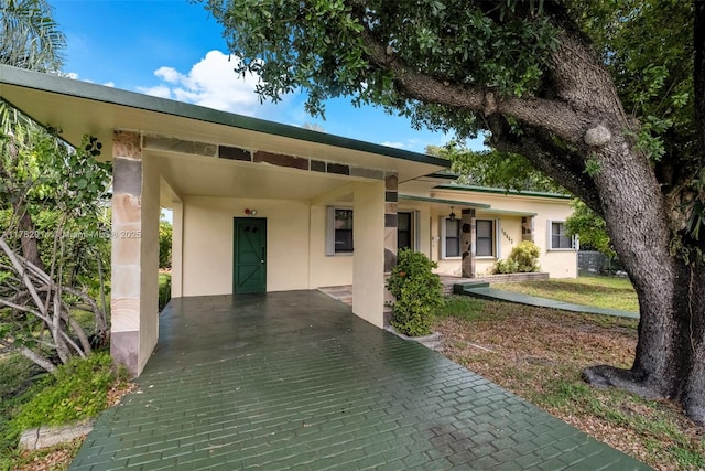 view of front of house featuring a carport and stucco siding