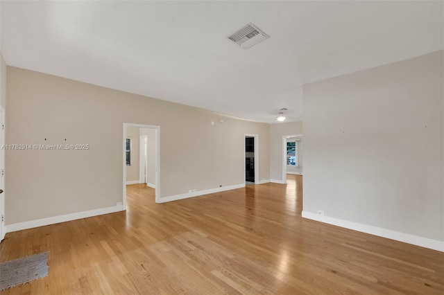 spare room featuring light wood-style flooring, baseboards, and visible vents