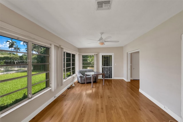 sunroom with visible vents, baseboards, and wood finished floors