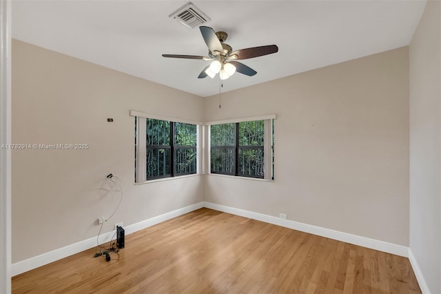spare room featuring light wood-style flooring, visible vents, baseboards, and ceiling fan