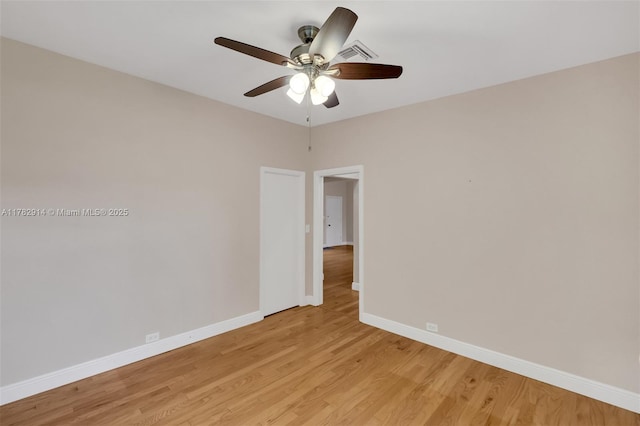 empty room with light wood-style floors, baseboards, visible vents, and ceiling fan