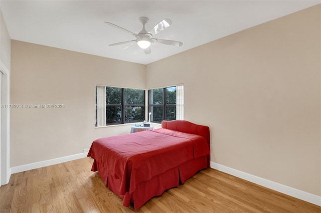 bedroom with light wood-style floors, baseboards, and ceiling fan