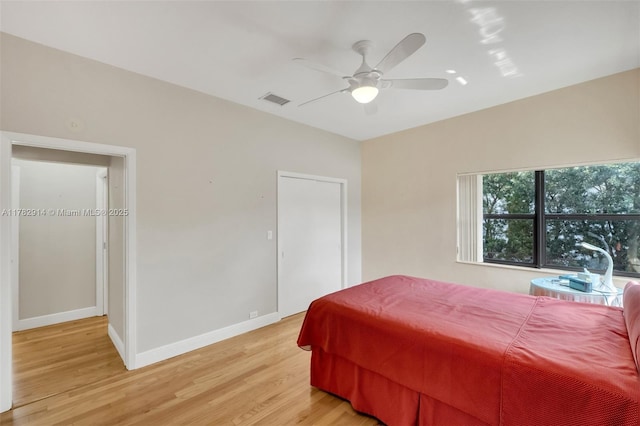 bedroom with light wood-style flooring, ceiling fan, baseboards, and visible vents