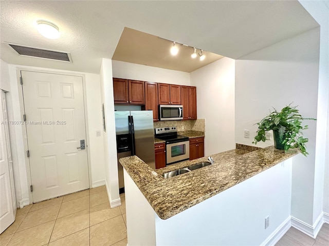 3001 NE 185th St Unit 336, Aventura, FL 33180 - kitchen featuring appliances with stainless steel finishes, a peninsula, visible vents, decorative backsplash, and a sink
