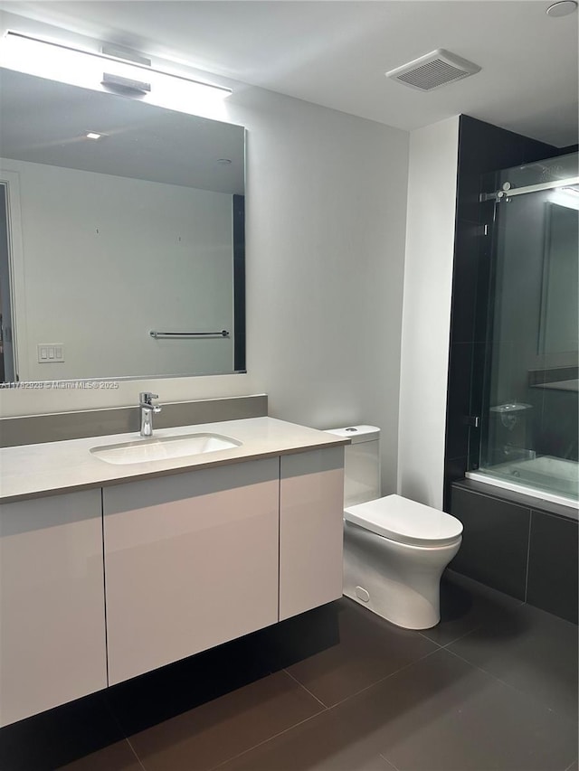 bathroom with visible vents, toilet, vanity, and tile patterned floors