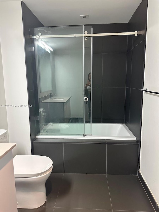 full bath featuring vanity, toilet, tile patterned flooring, and shower / bath combination with glass door