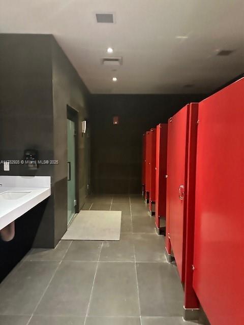 hallway featuring light tile patterned flooring and visible vents