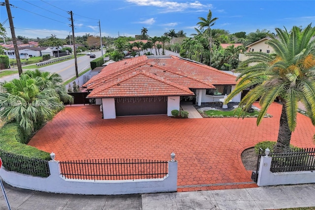 view of front of home featuring a tiled roof, a garage, stucco siding, and fence