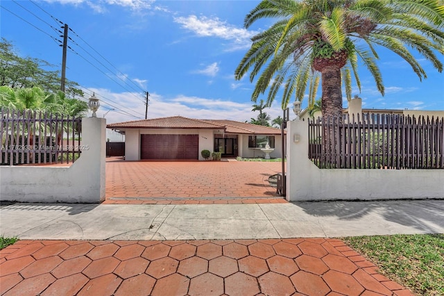 single story home featuring an attached garage, a fenced front yard, stucco siding, and driveway