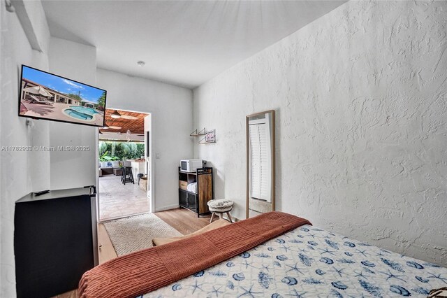bedroom featuring a textured wall and wood finished floors