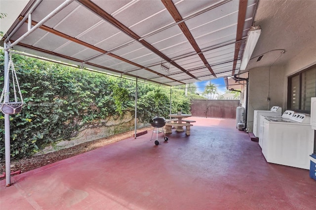 view of patio / terrace with fence, washing machine and dryer, and area for grilling