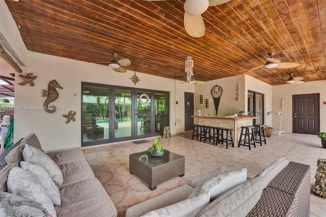 living room featuring wooden ceiling, ceiling fan, and a healthy amount of sunlight