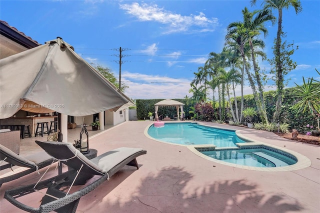 view of pool featuring outdoor dry bar, a patio area, and a pool with connected hot tub
