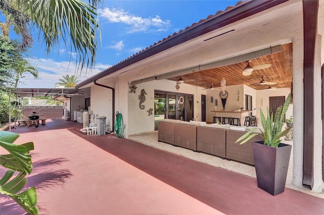 view of patio featuring outdoor lounge area, ceiling fan, and washer / dryer