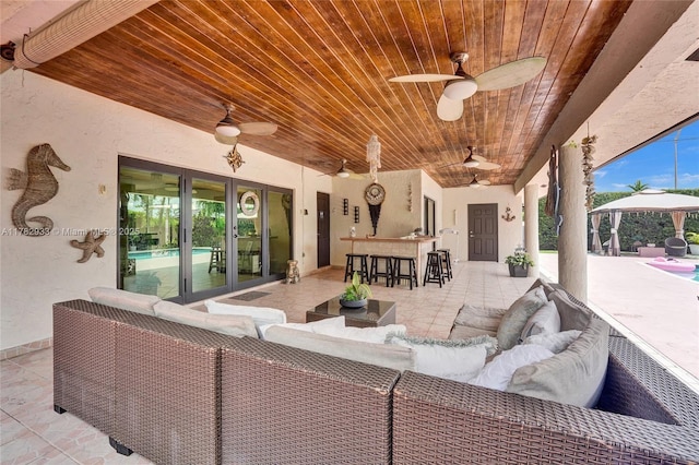 view of patio featuring outdoor dry bar, french doors, a ceiling fan, an outdoor hangout area, and a gazebo