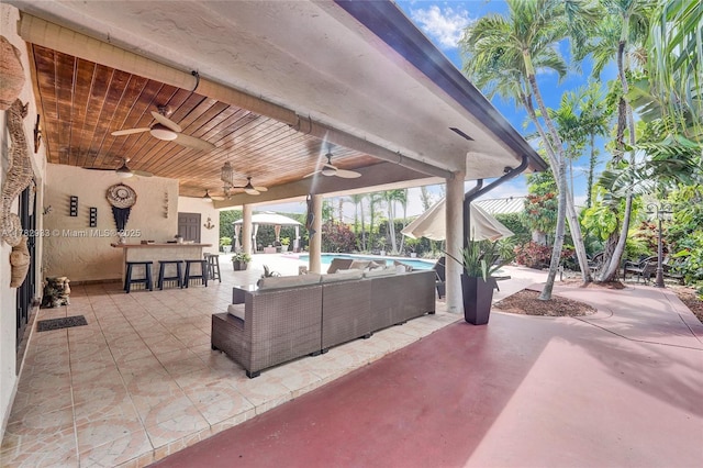 view of patio featuring an outdoor pool, outdoor lounge area, outdoor dry bar, and ceiling fan