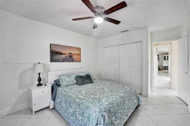 bedroom with light tile patterned floors, visible vents, a closet, and baseboards