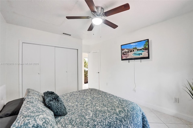bedroom with visible vents, baseboards, a closet, ceiling fan, and light tile patterned flooring