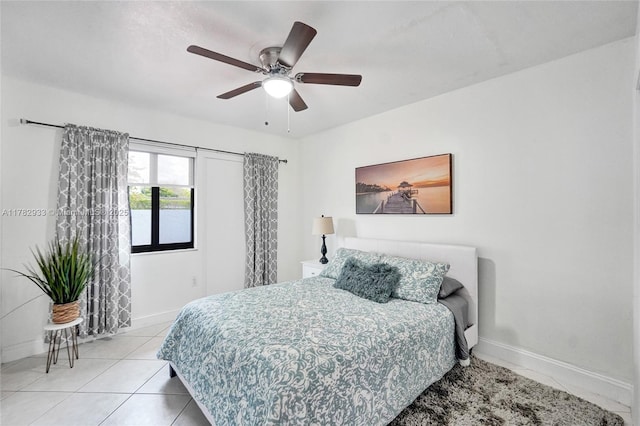 bedroom featuring light tile patterned flooring, baseboards, and a ceiling fan