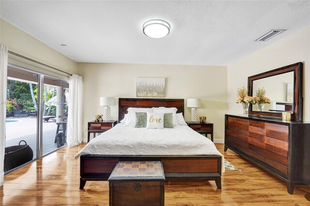 bedroom featuring light wood-type flooring, visible vents, access to exterior, and baseboards