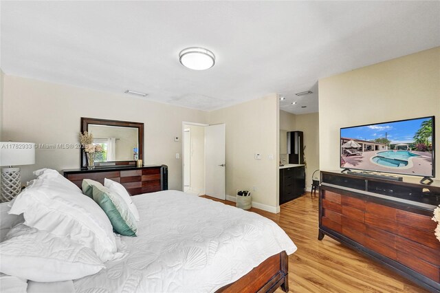 bedroom with visible vents, light wood-style flooring, and baseboards